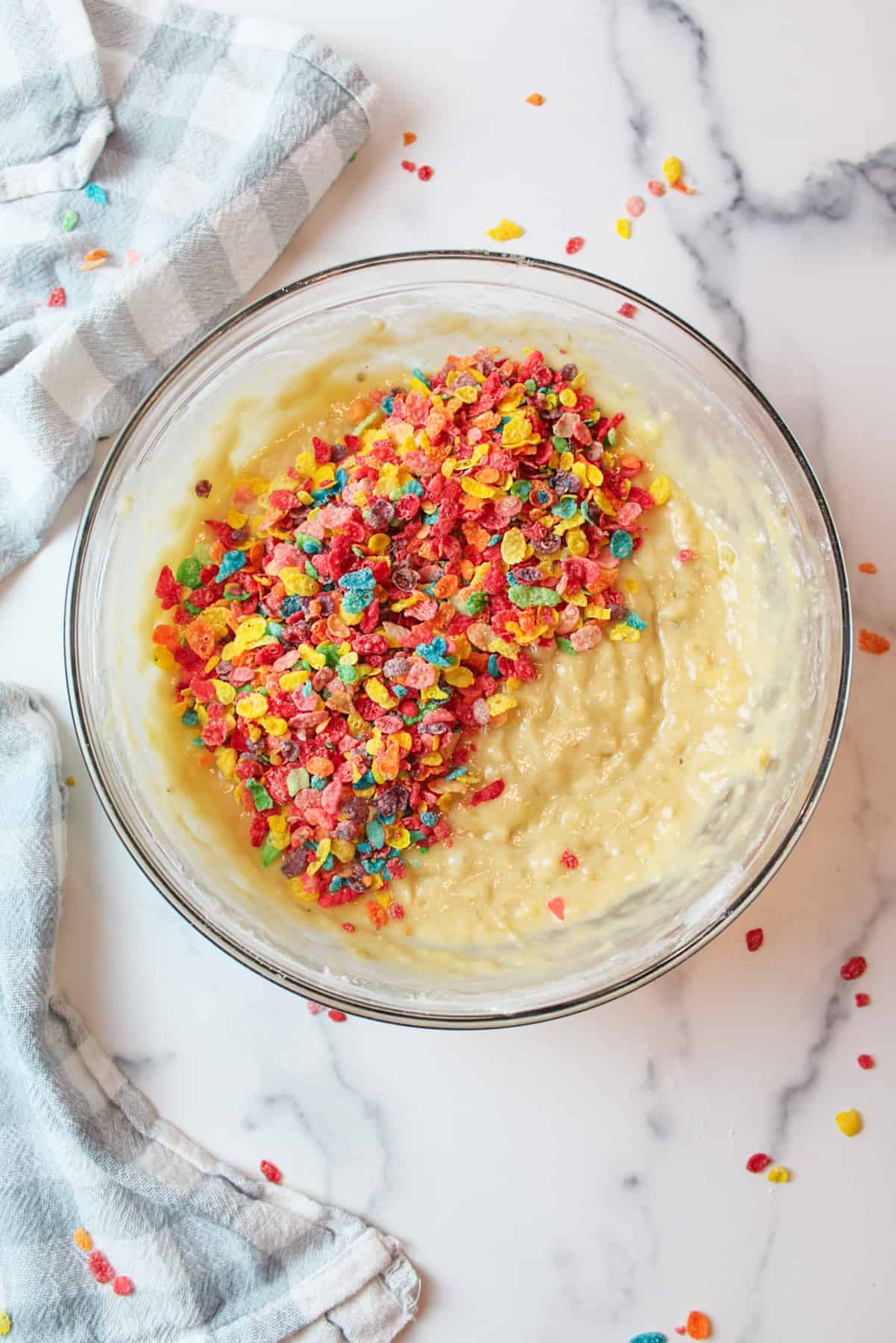 fruity pebbles cereal on banana bread in a mixing bowl