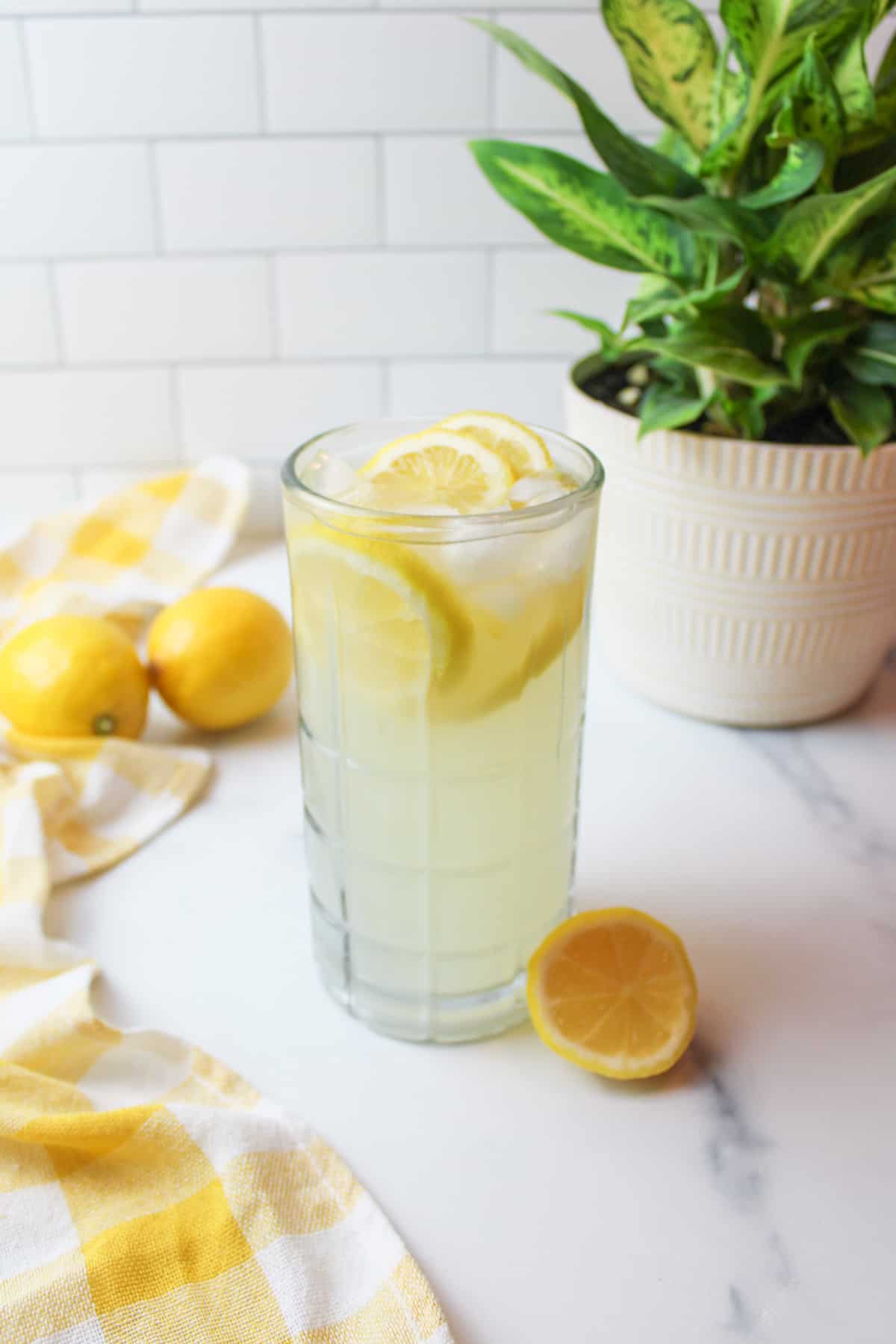a cup of single serving lemonade with ice cubes and sliced lemon