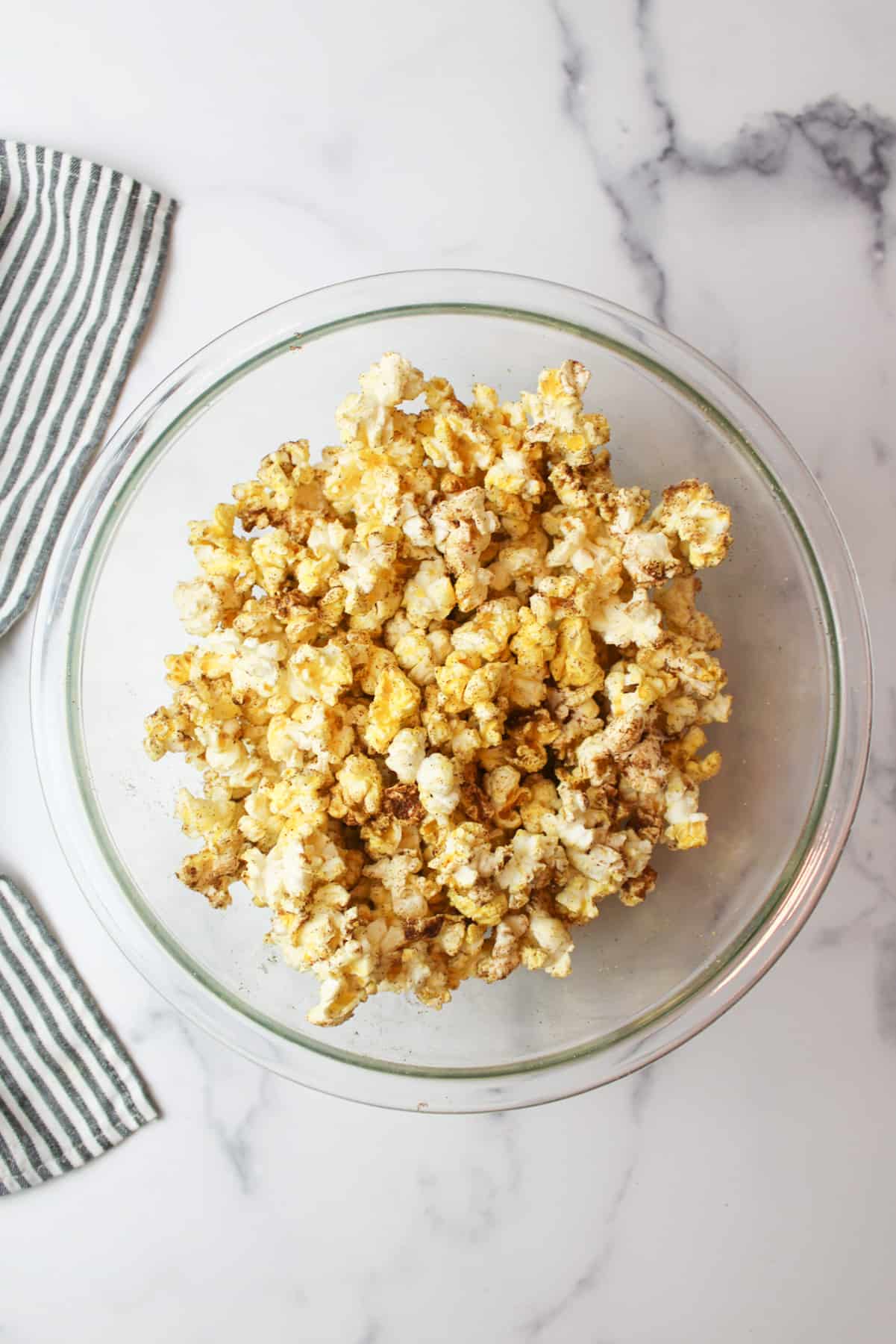 snickerdoodle popcorn in a glass mixing bowl