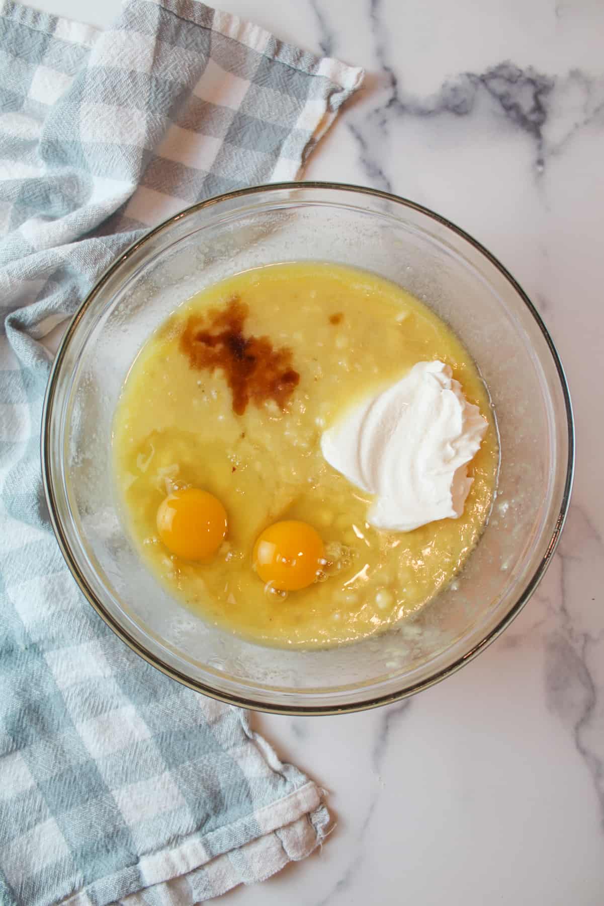 vanilla sour cream and eggs added to wet banana mixture in a mixing bowl
