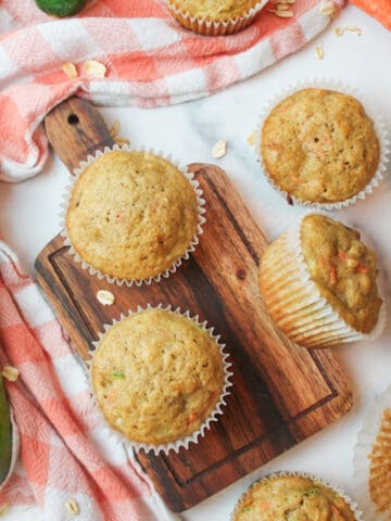 aerial view of zucchini carrot oatmeal muffins with fresh zucchini and carrots to the sides