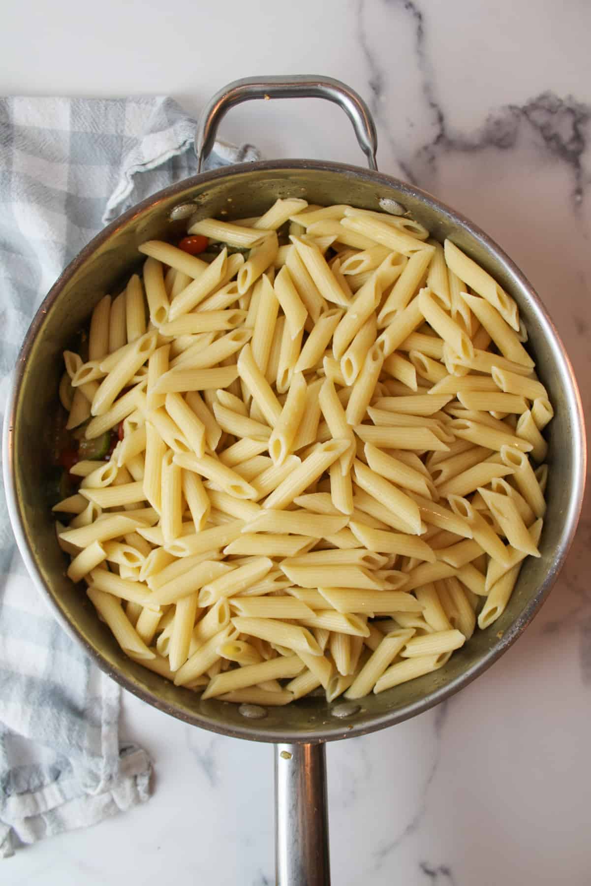 cooked penne pasta added to large pot