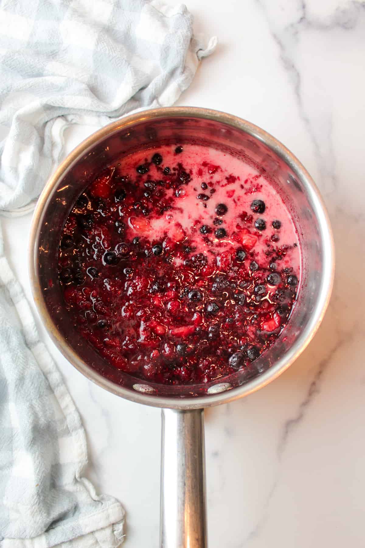 cornstarch slurry in a pan with mashed cooked berries