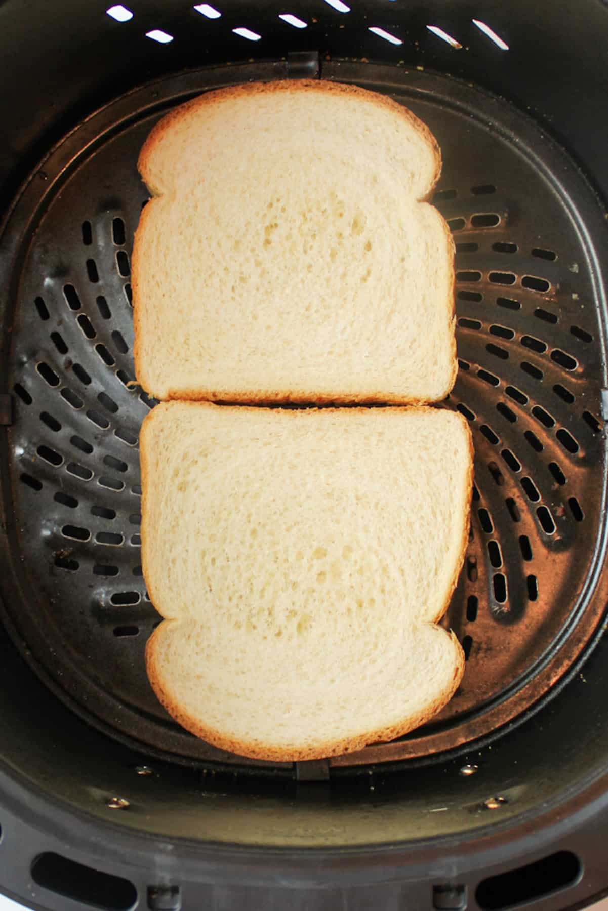 sandwich bread butter side down in an air fryer basket