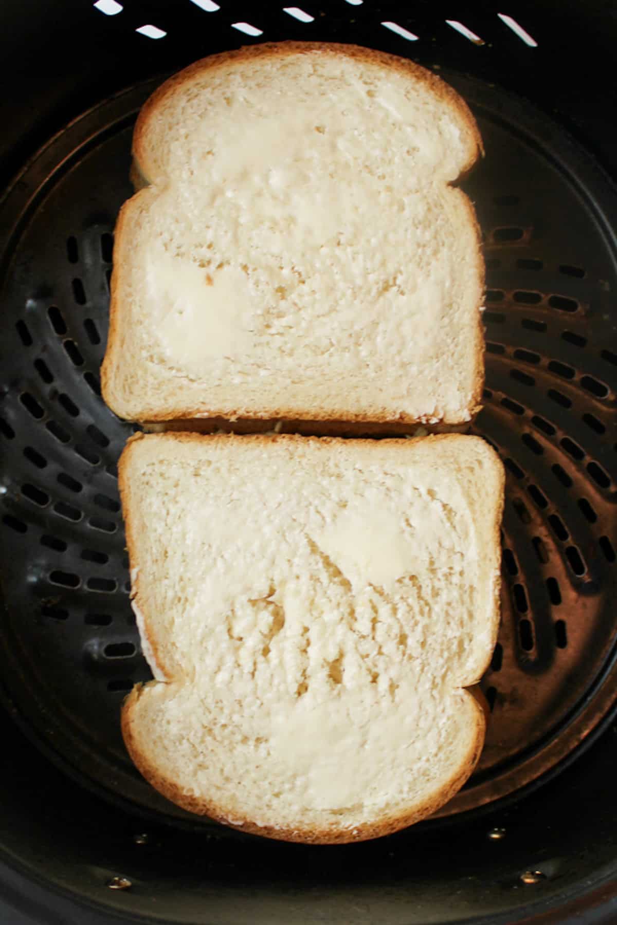 buttered tuna and cheese sandwich in an air fryer basket