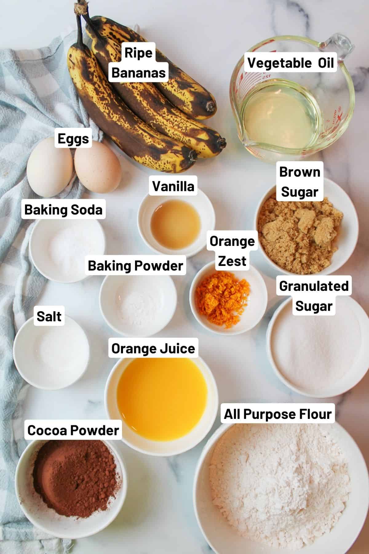labeled ingredients needed to make chocolate orange banana bread.