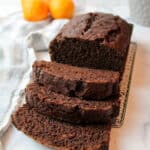a close up of sliced chocolate orange banana bread on a wire rack