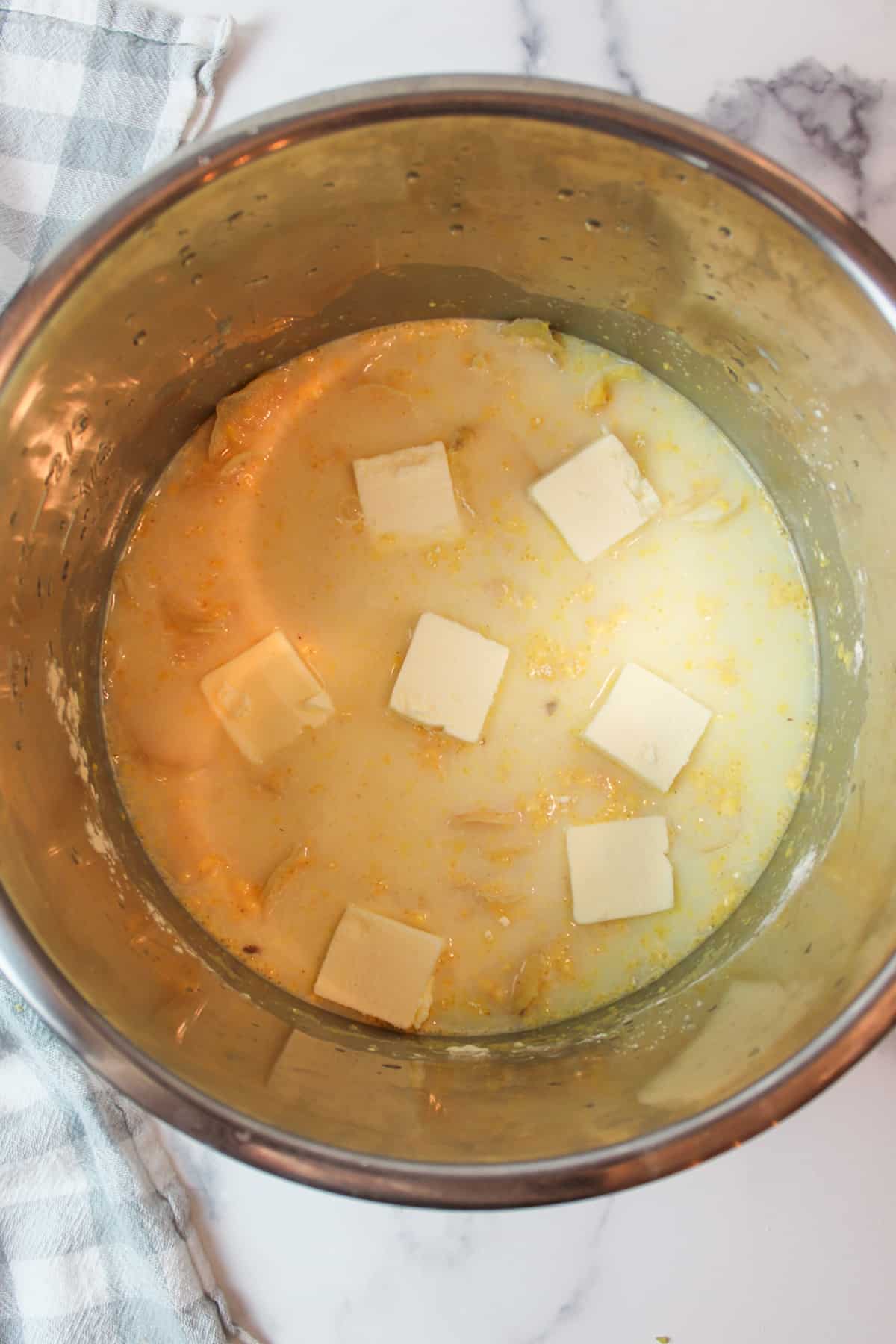 pads of butter on top of cheesy potatos for au gratin potatoes in an instant pot.