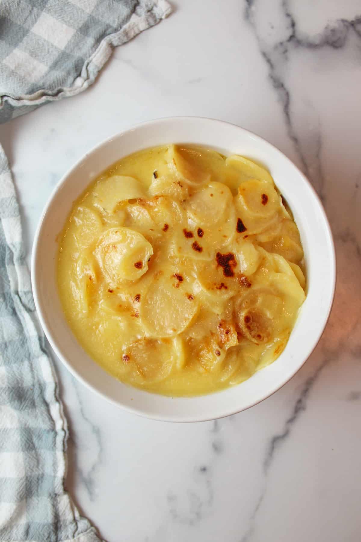 broiled au gratin potatoes in a baking dish.