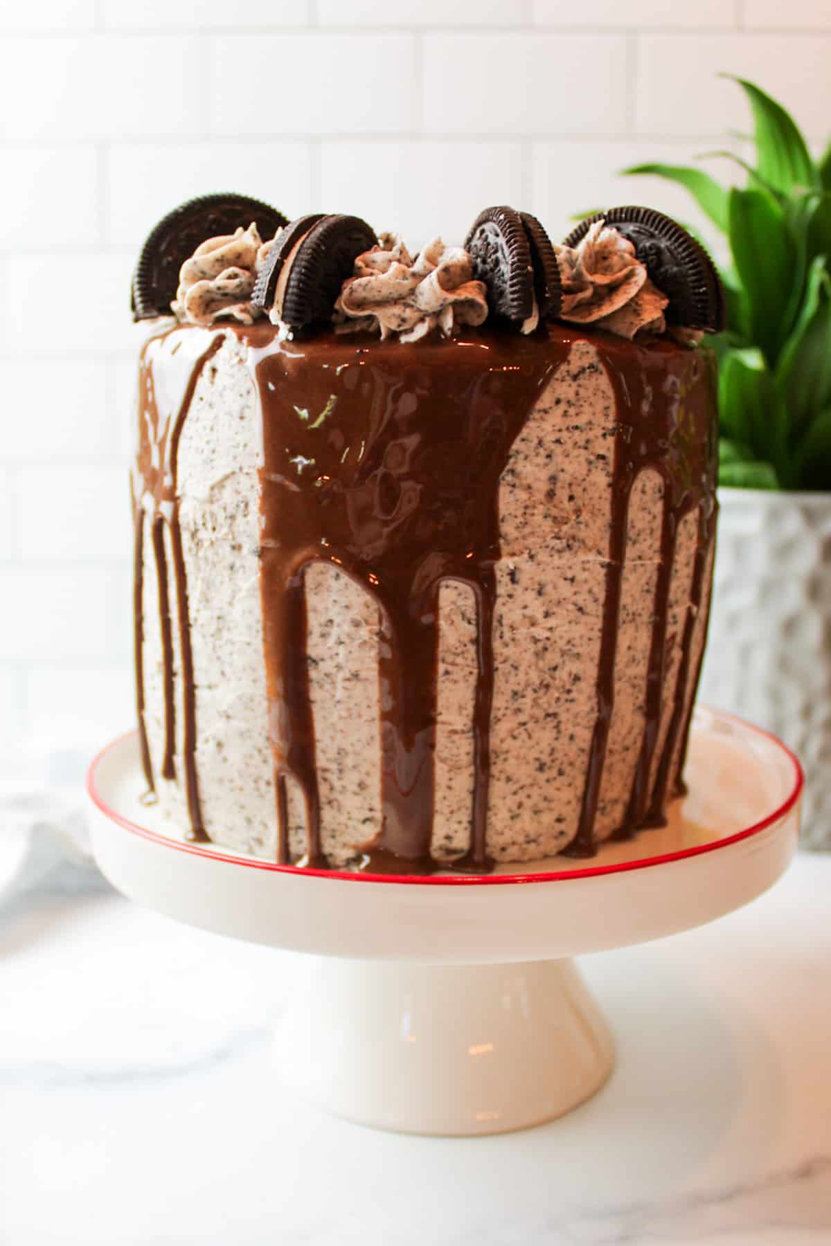 oreo buttercream and chocolate drip on a tall layer cake