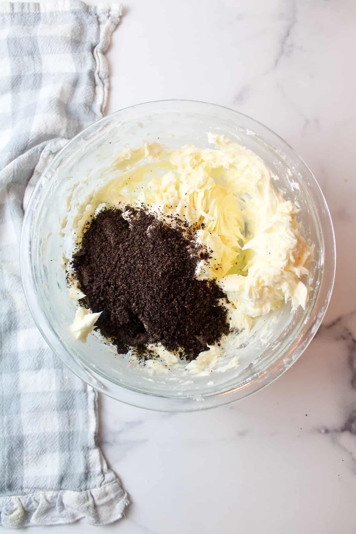 oreo cookie crumbs in a mixing bowl with butter sugar mixture