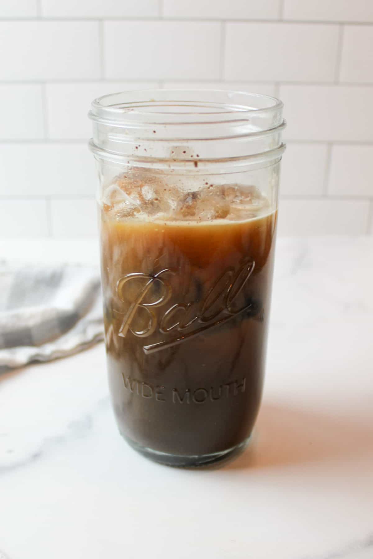 ice cubes in a tall glass cup full of oreo cookie coffee.