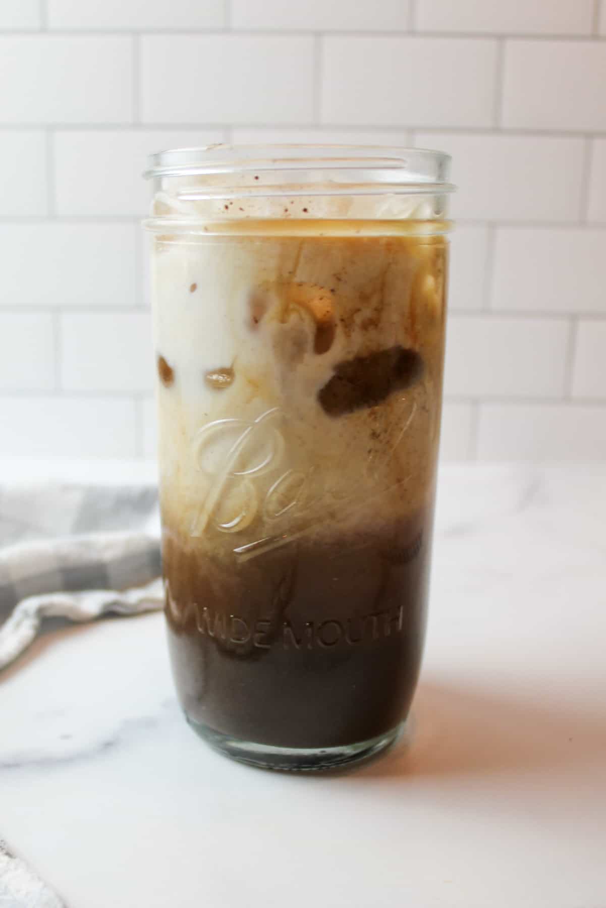 milk added to tall glass cup full of oreo coffee