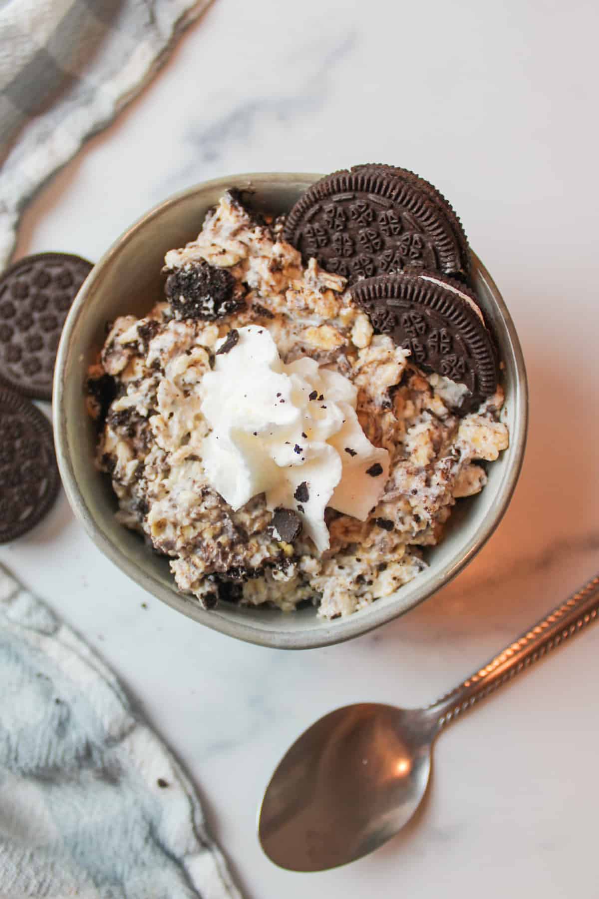 aerial view of oreos overnight oats topped with whipped cream and cookies