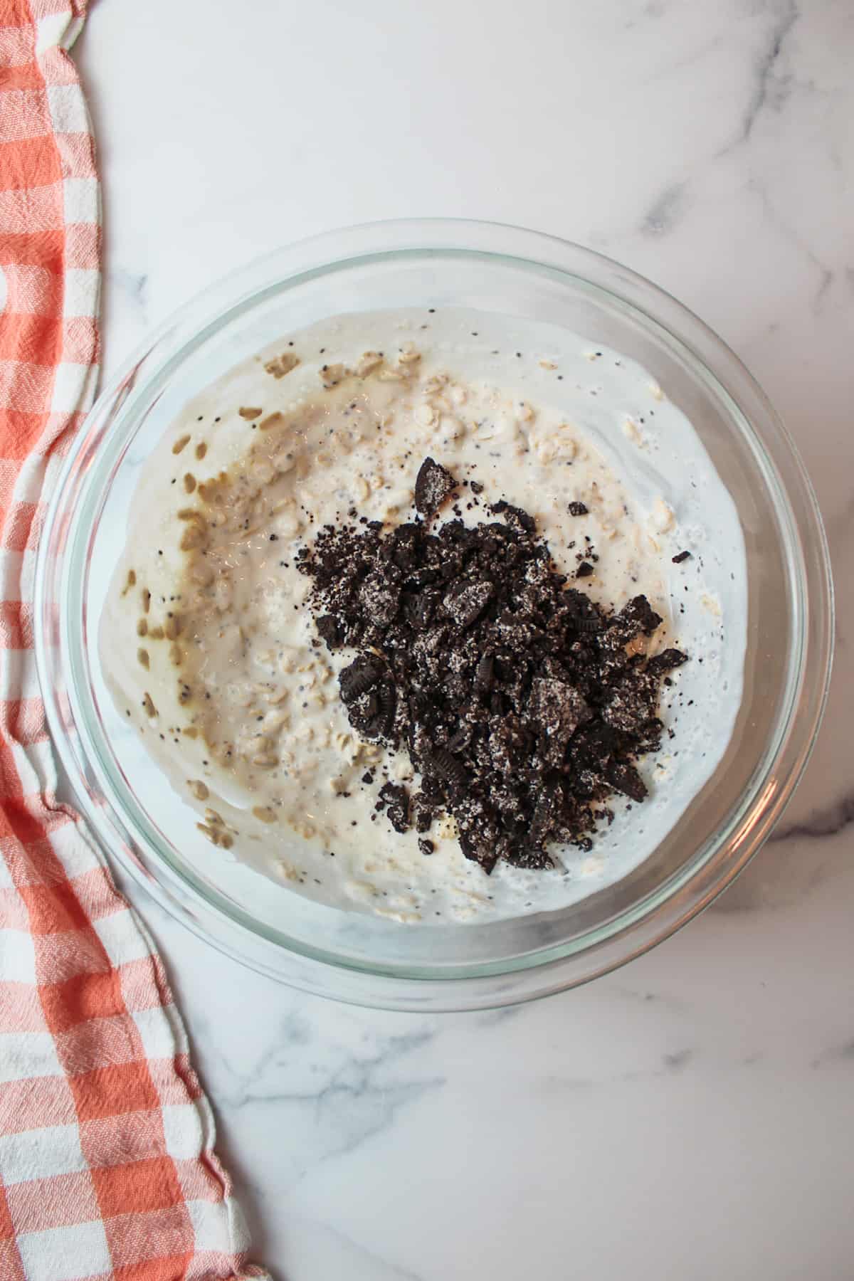 crushed oreos in a mixing bowl with overnight oats mixture