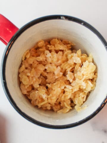 a close aerial view inside a mug with a rice krispie treat mixture inside
