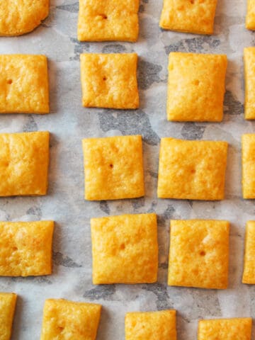 cheese cracker squares on parchment paper.