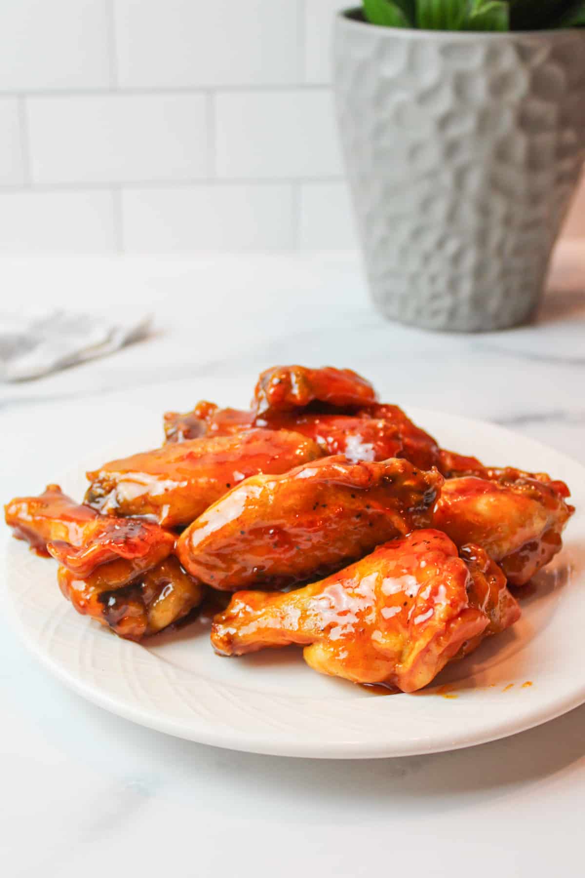 honey gold chicken wings on a white plate.