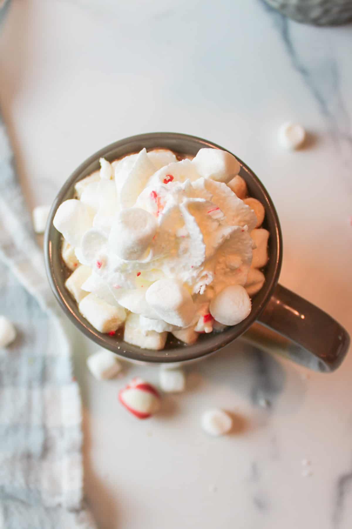 aerial view of hot chocolate coffee in a mug with whipped cream and marshmallows on top