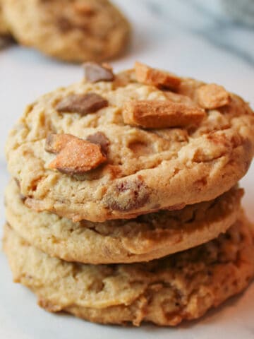 an upclose view of three stacked butterfinger cookies