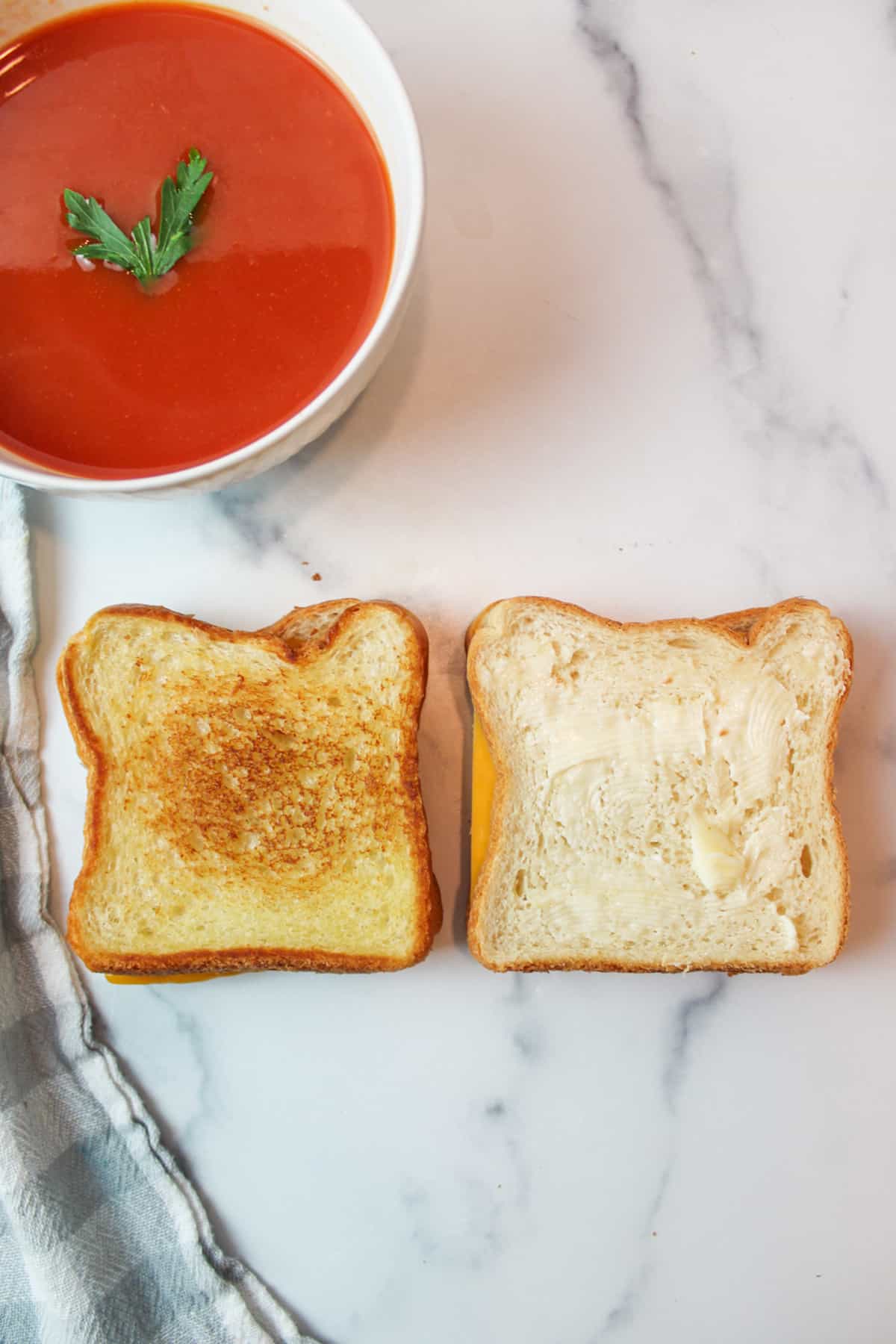 two grilled cheese sandwiches next to eachother, one cooked and one not, with a bowl of soup at the top