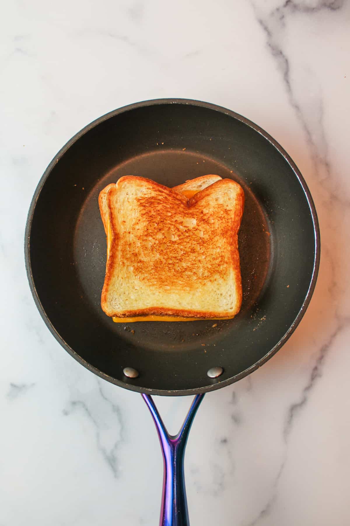 a cooked rilled cheese sandwich in a skillet