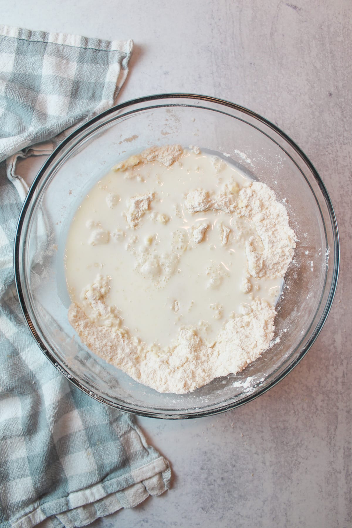 milk added to butter and flour mixture in a glass mixing bowl