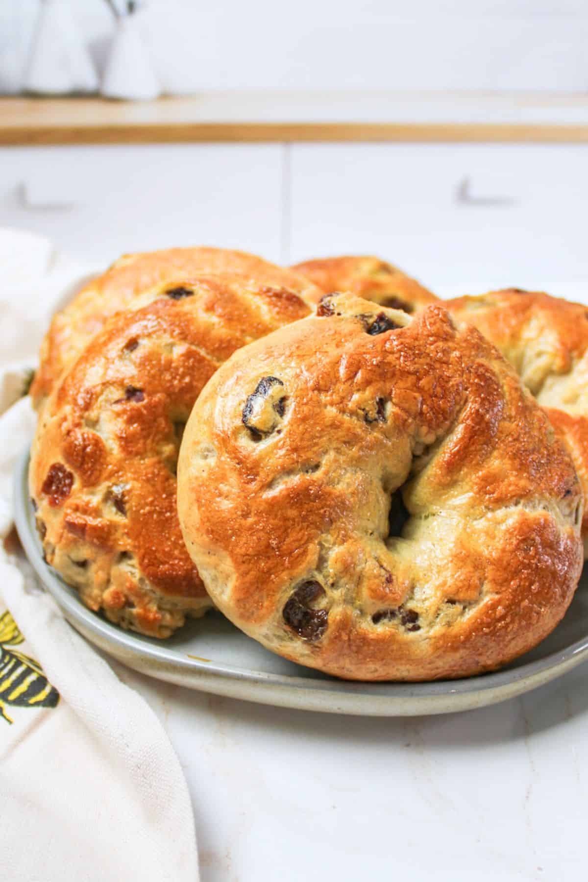 a plate with several cinnamon raisin bagels on top.