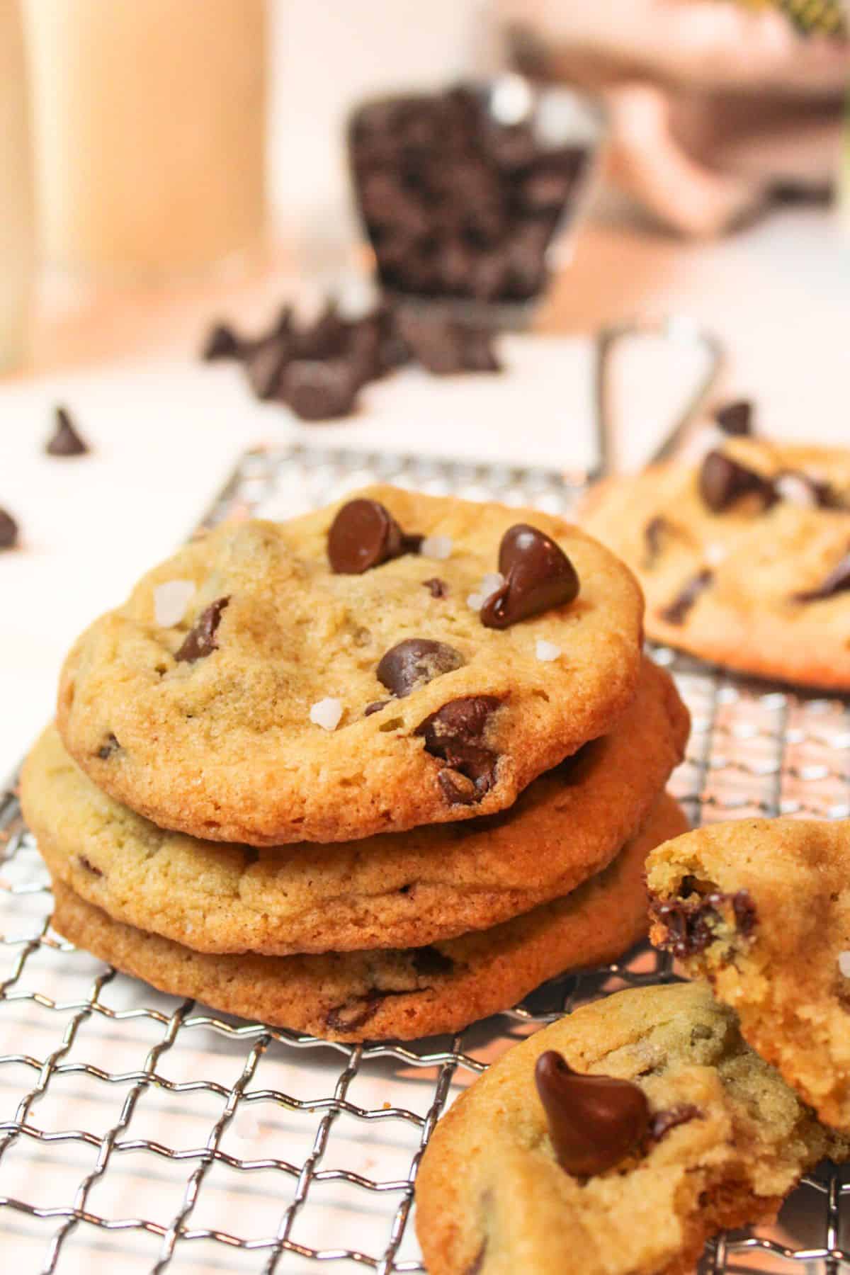 stacked chocolate chip cookies on a wire rack.