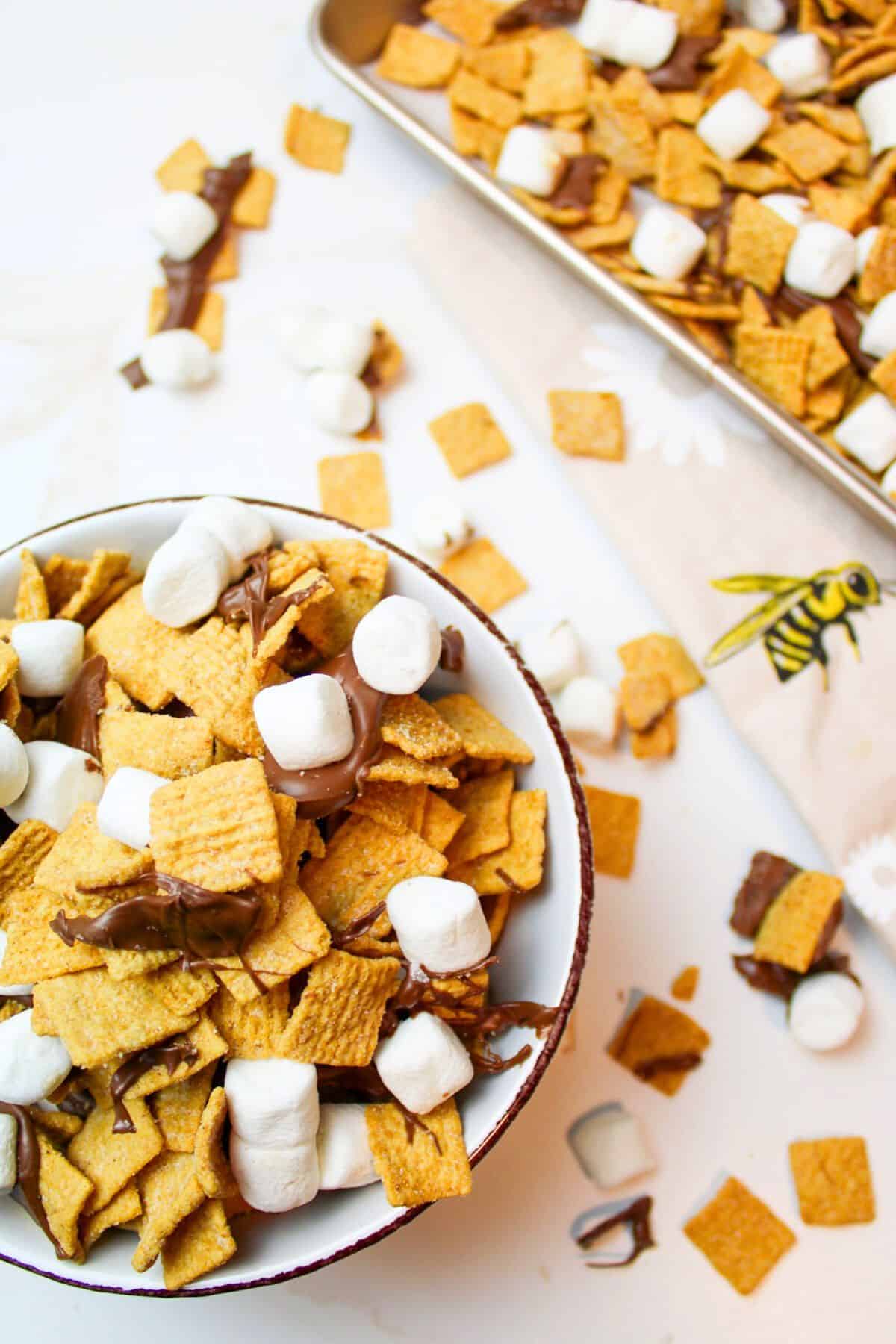 smores snack mix in a bowl and on a baking sheet.