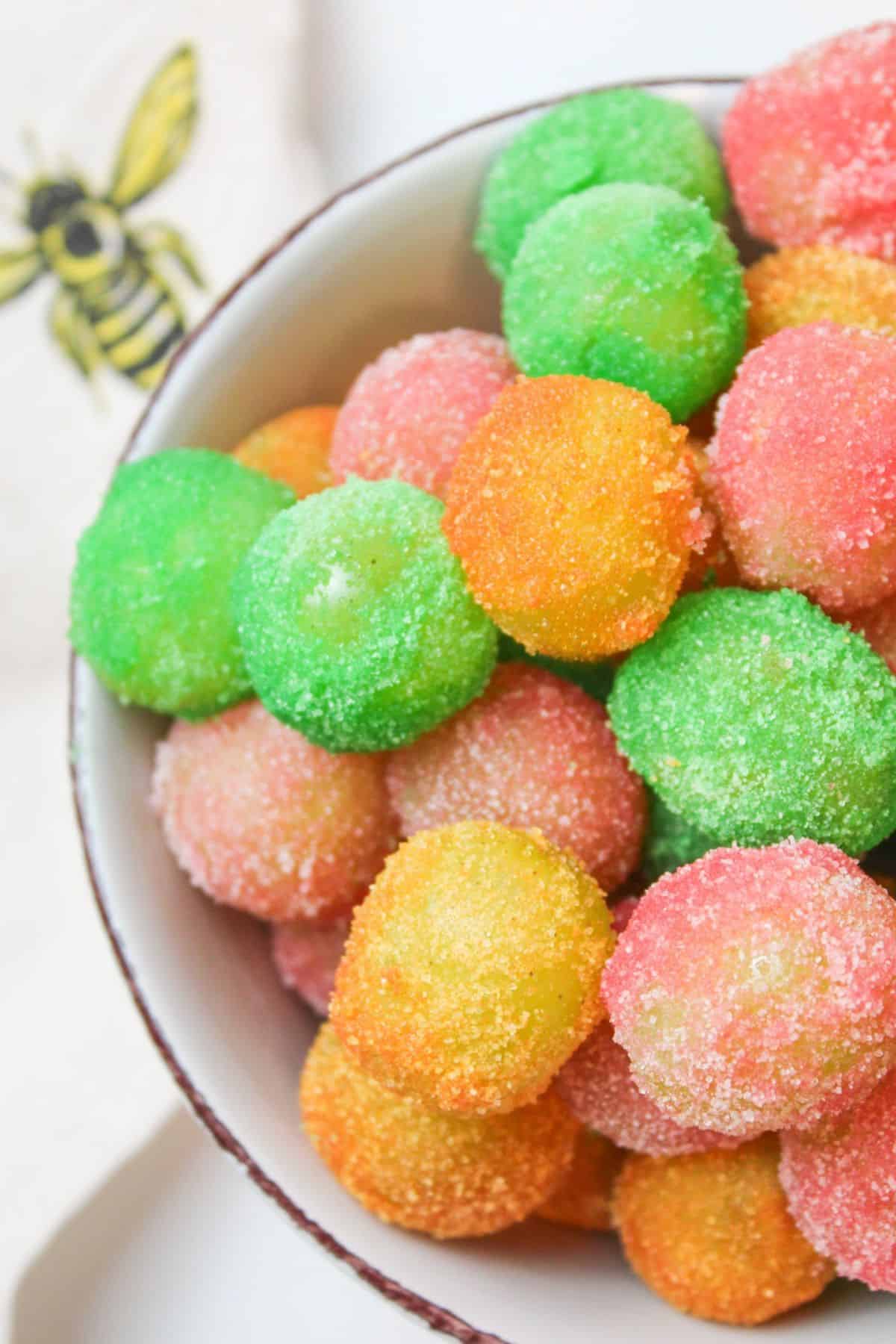half of a bowl filled with sour patch grapes.