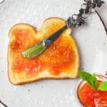 orange marmalade on toast with a knife.