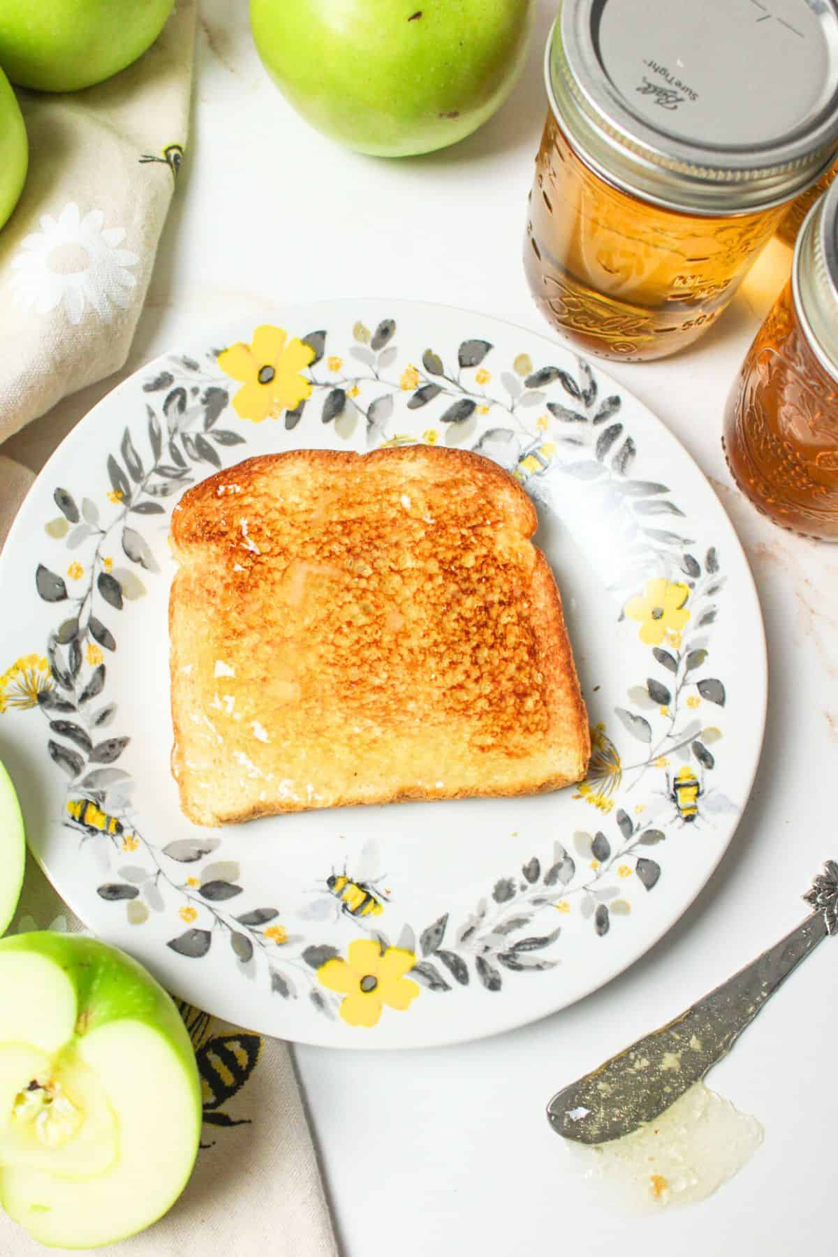 apple jelly spread over toast on a plate.