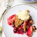 plate filled with cherry apple crisp with a fork to the side.