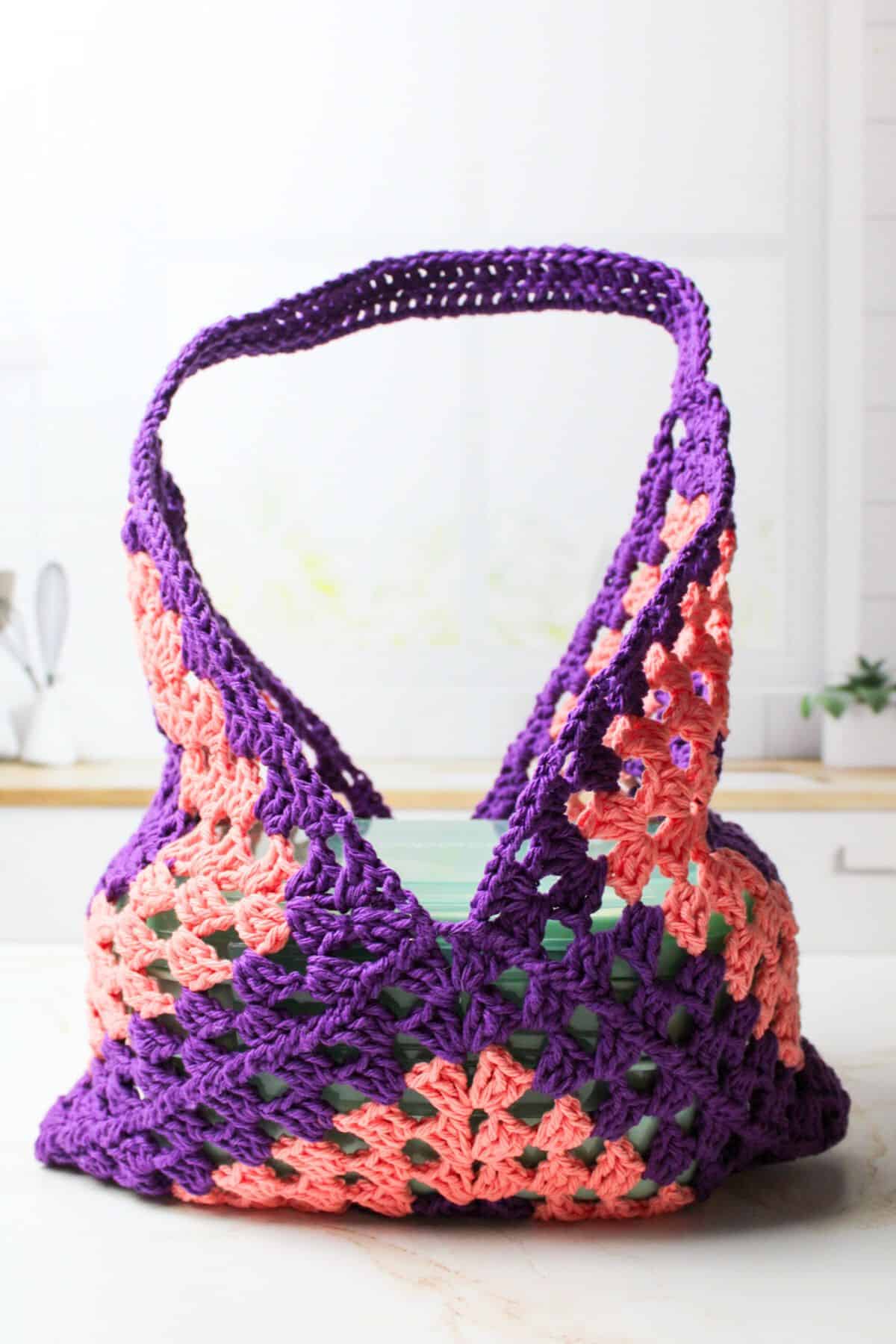 crochet bento bag holding bento box.