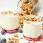 two small jars of homemade yogurt with jam and granola.