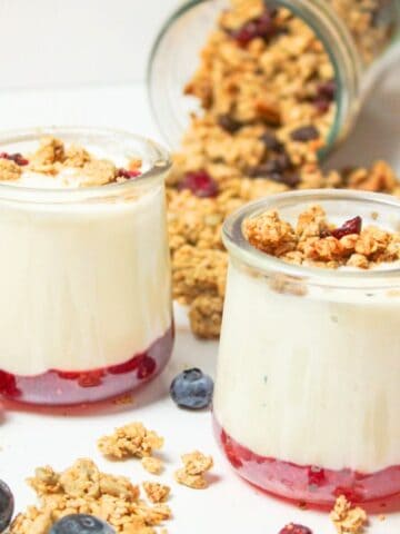 two small jars of homemade yogurt with jam and granola.