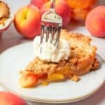a slice of peach crumble pie topped with ice cream.