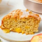 a slice of peach coffee cake on a plate.
