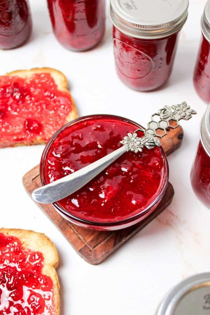 strawberry jam in a bowl topped with a fancy knife.