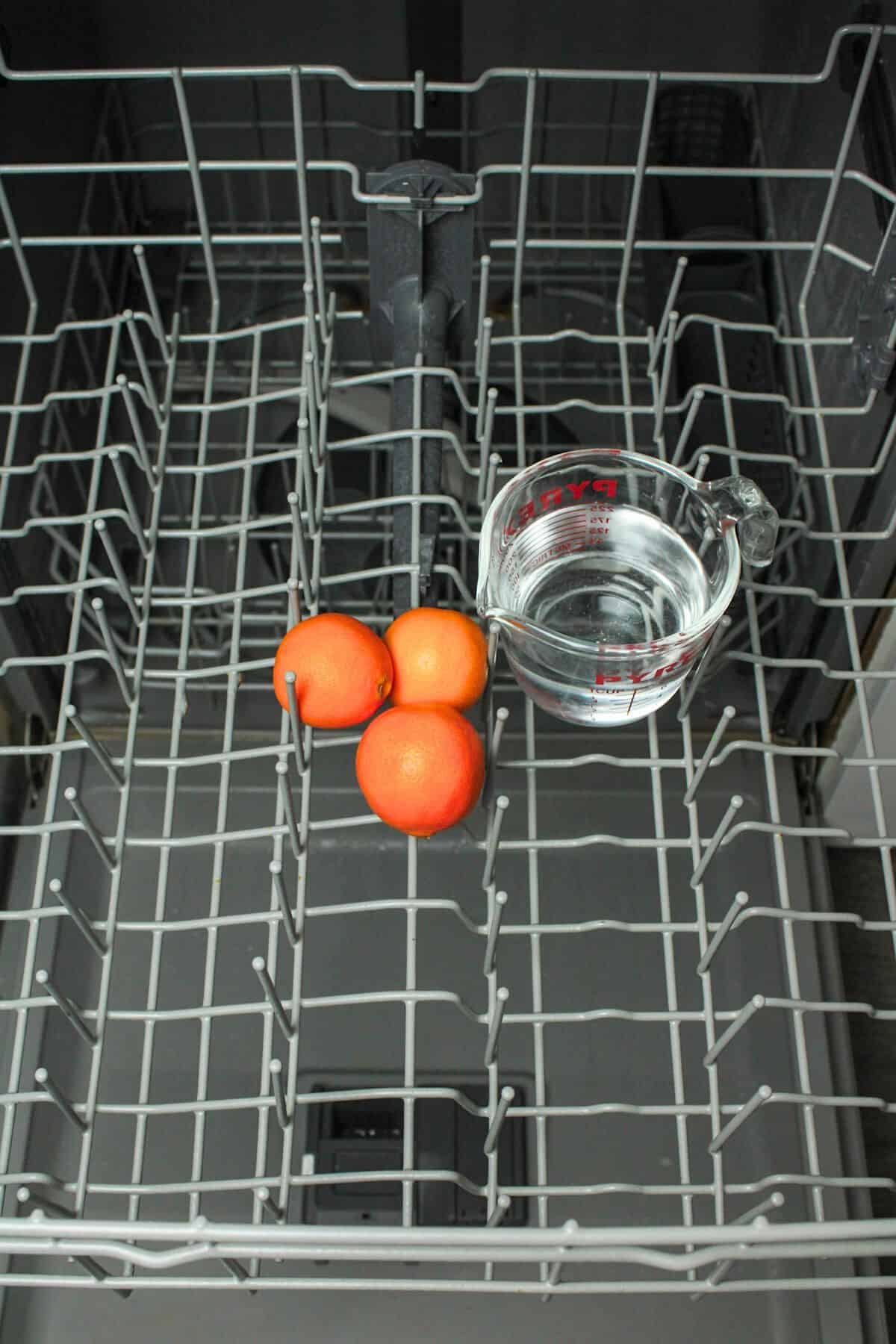 oranges and vinegar on top rack of dishwasher.