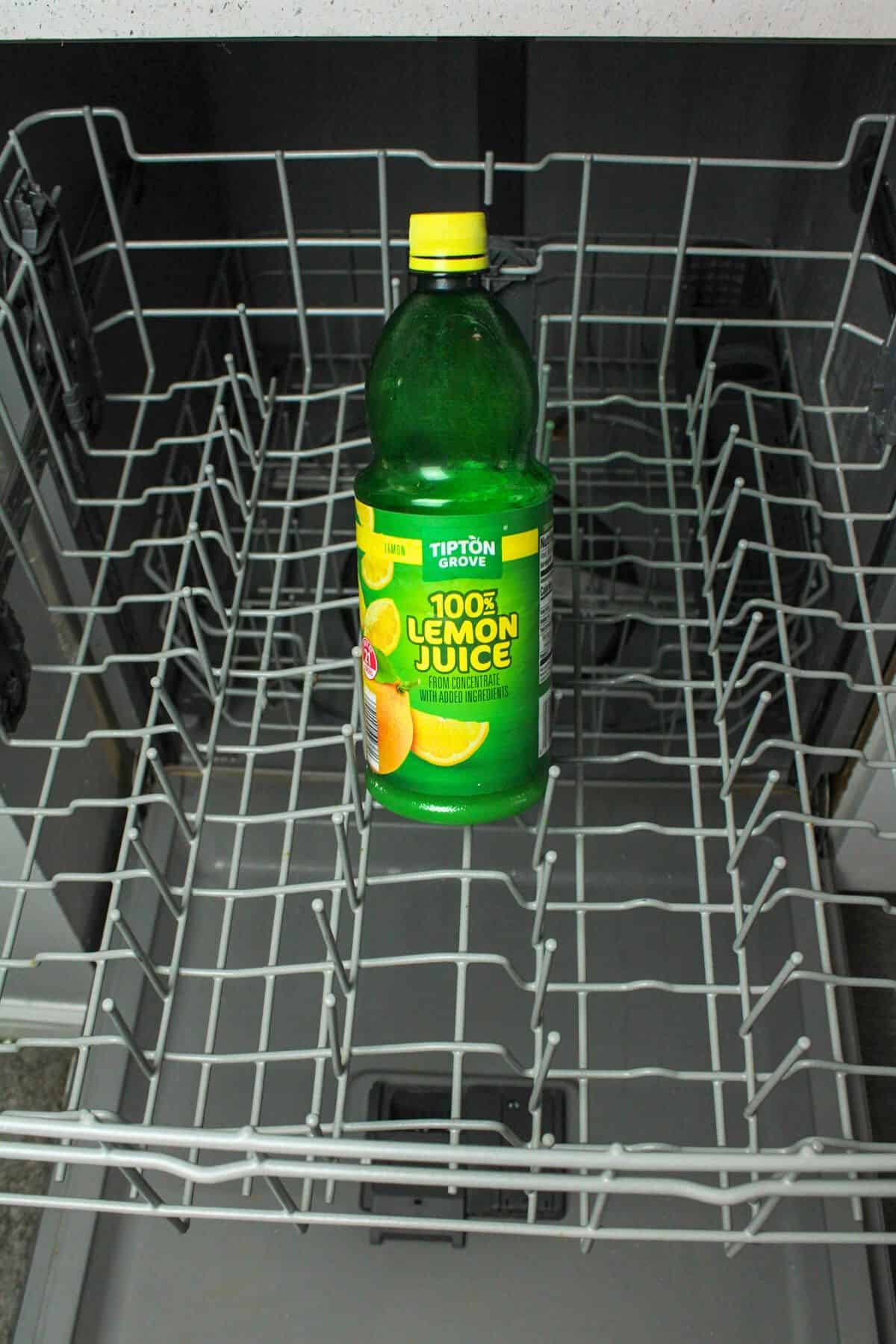 bottle of lemon juice on top rack of dishwasher.