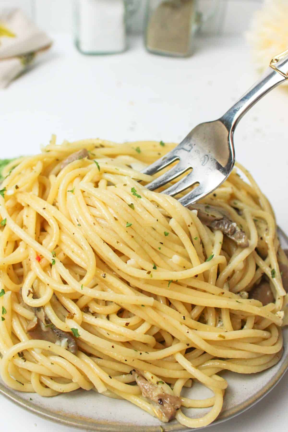 mushroom garlic spaghetti on a plate with a fork.