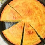 sliced sourdough cornbread in a cast iron skillet.
