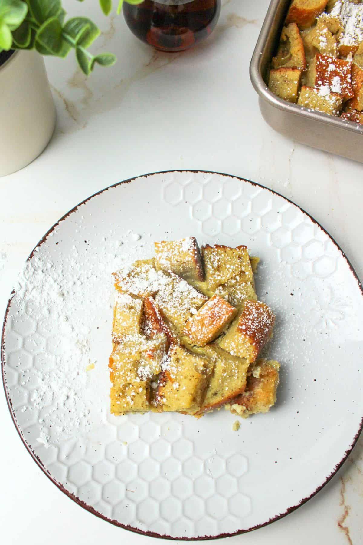 french toast bake on a plate topped with powdered sugar.