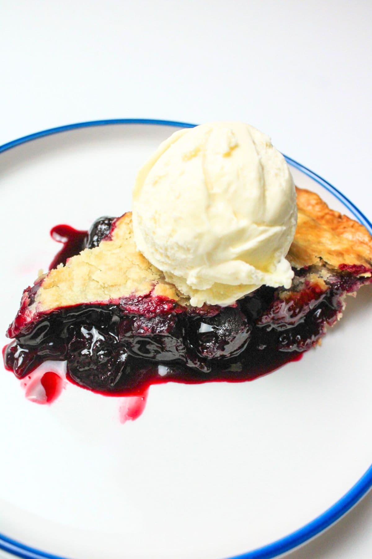 a slice of cherry pie with ice cream on top.