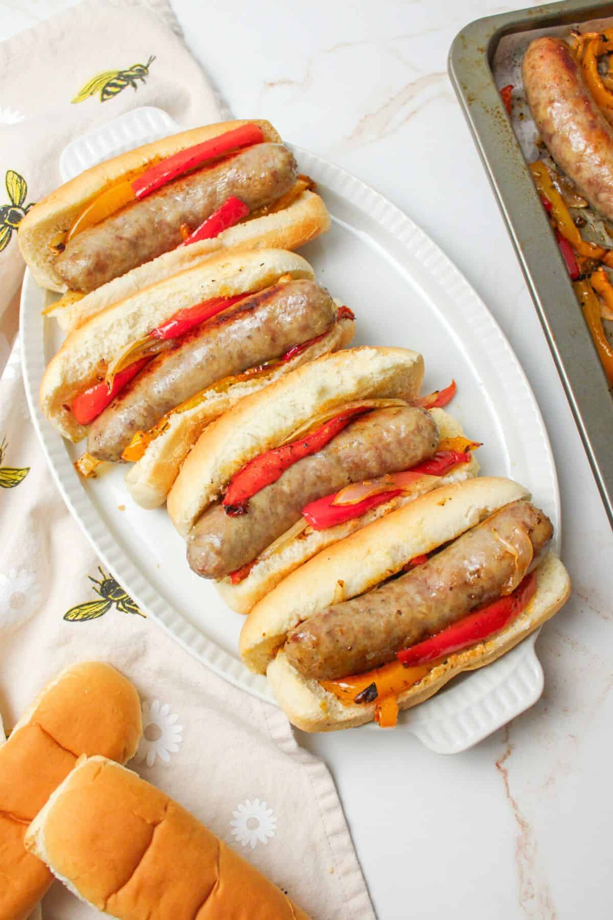 brats with roasted bell peppers and onions on buns.