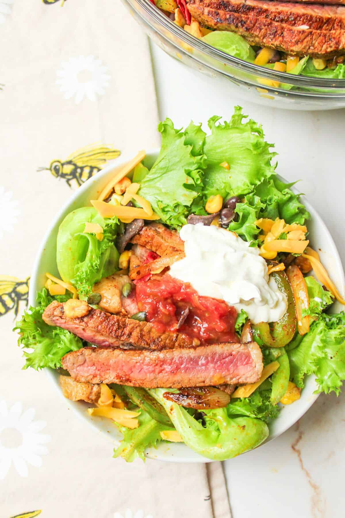 fajita salad in a bowl with toppings.