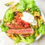 a bowl of fajita taco salad with toppings.