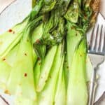 roasted bok choy on a plate with a fork.
